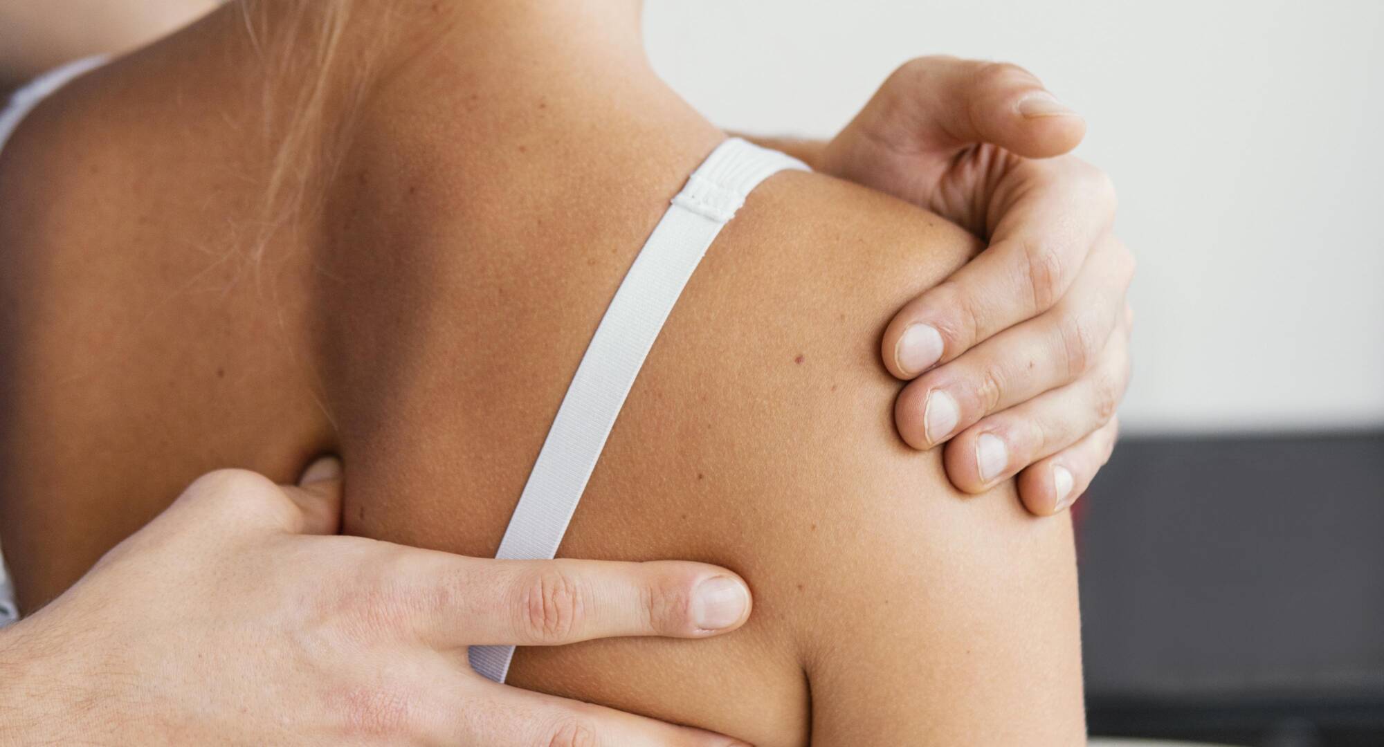 male osteopathic doctor checking female patient s scapula