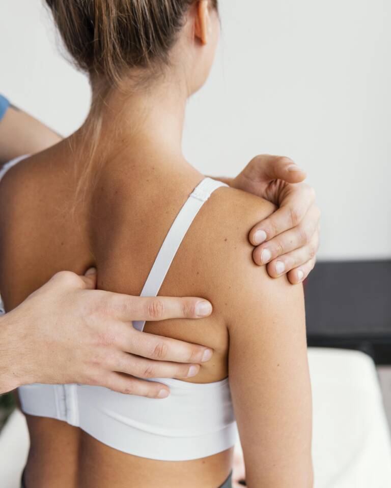 male osteopathic doctor checking female patient s scapula